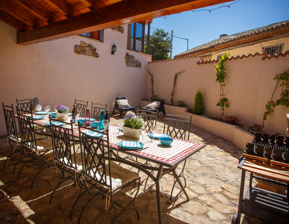 Patio con mesa y sillas de casa rural en Braojos Madrid