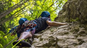 Un deportista asciende por una pared rocosa.