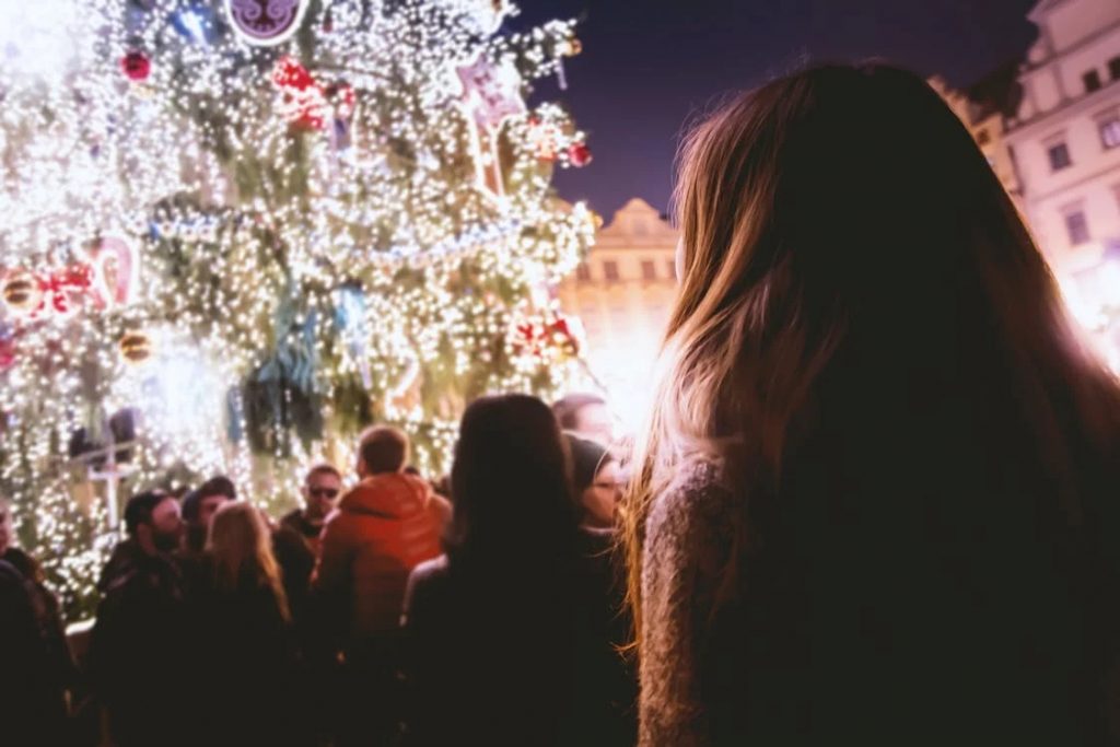 Personas junto a gran árbol de Navidad