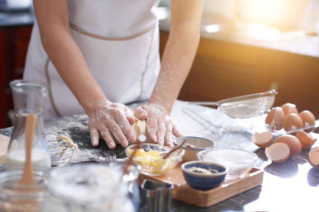 mujer irreconocible pie mesa cocina amasar mano 1