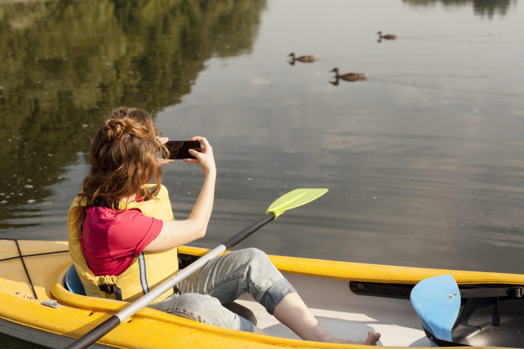 mujer en kayak y tomando fotos