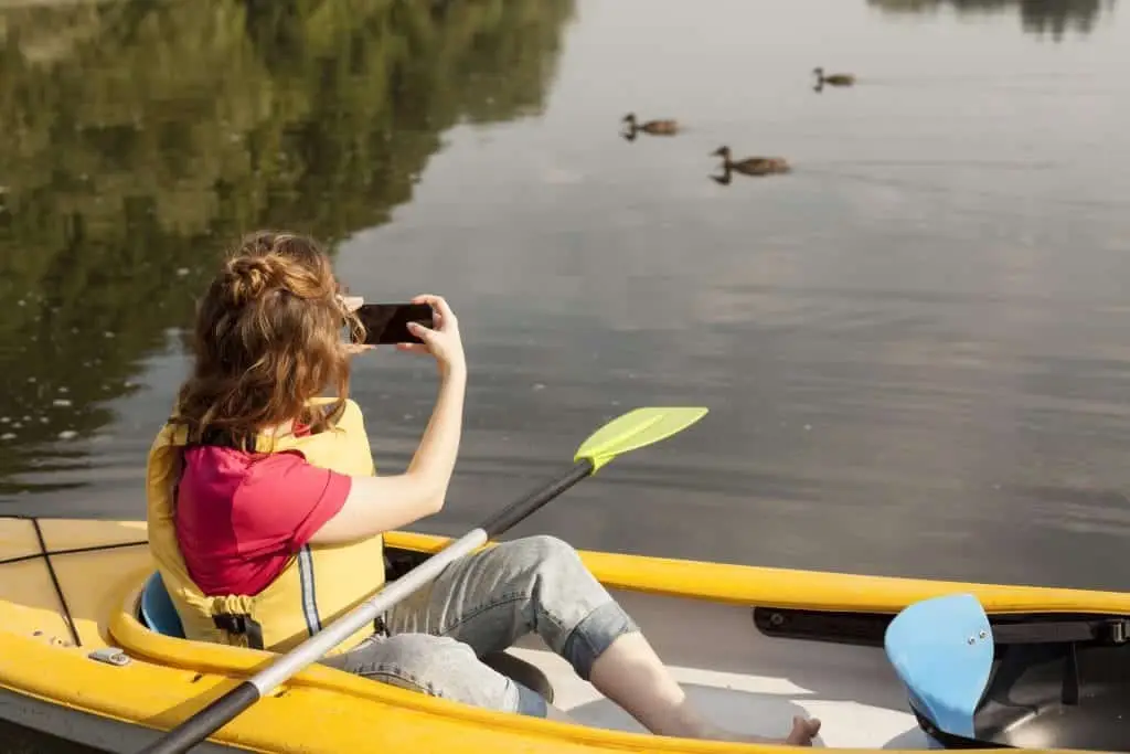 mujer en kayak y tomando fotos