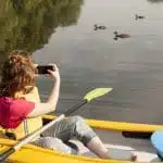 mujer en kayak y tomando fotos