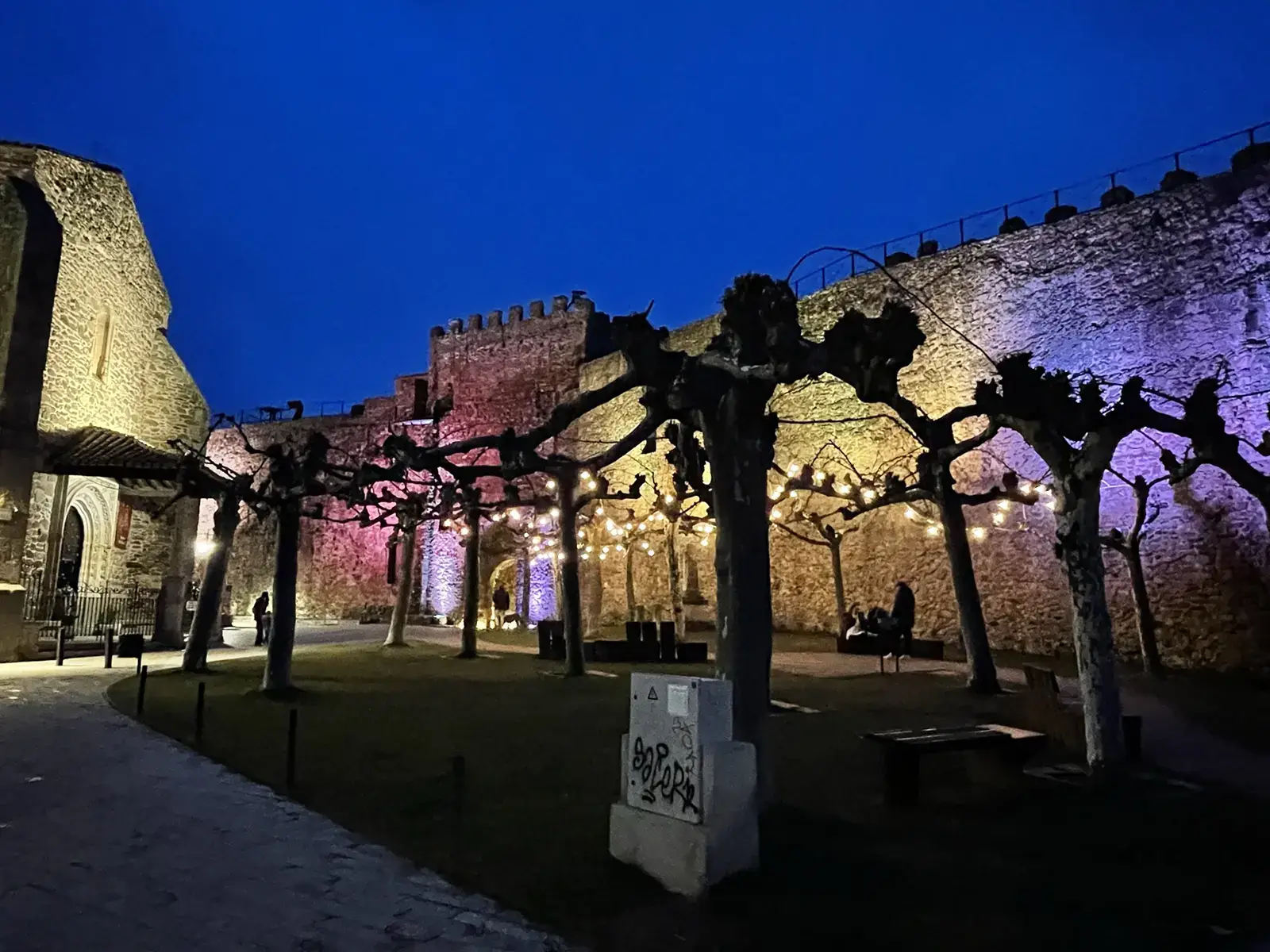Muralla de Buitrago del Lozoya iluminada por la noche durante un evento